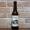 Bouteille de Session IPA bio Soma 33 cl à 4,2 %, photographiée devant un mur de briques